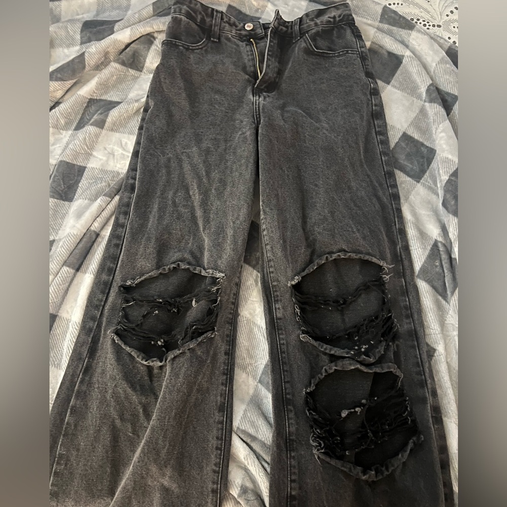 black baggy jeans with three big holes below the knee